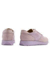 Paire de baskets en cuir et daim de couleur violet clair, vues de dos et de côté sur fond blanc.