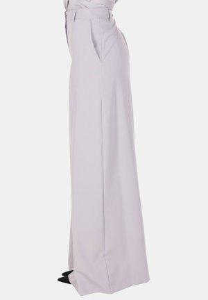 Pantaloni a vita alta, gamba larga di colore lavanda chiaro con passanti per cintura, tasche laterali e scarpe nere con punta affilata.