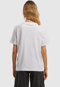 White cotton t-shirt with a crew neck and short sleeves, featuring a relaxed fit and smooth texture. No notable embellishments or patterns.