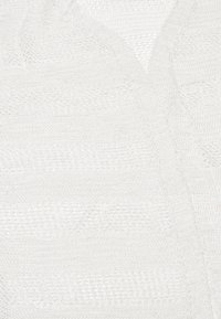 Pletený bílý cardigan s texturovaným vzorem s diagonálními pruhy, hlubokým V-výstřihem a měkkou, lehkou tkaninou.
