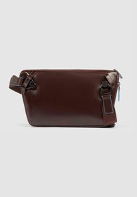 Borsa a tracolla in pelle marrone con una texture liscia, chiusura con zip e dettagli blu. Presenta una tracolla laterale e una chiusura a fibbia distintiva.