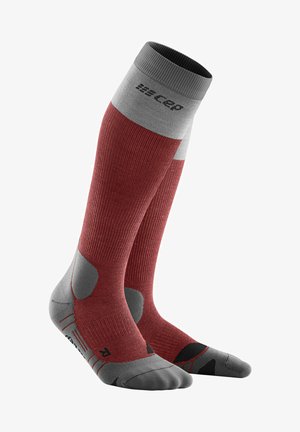 Kniesokken tot aan de knie met een rode pasvorm, grijze geribbelde boord, versterkte teen en hiel. Voorzien van ventilatiezones en een gestructureerd grippatroon.