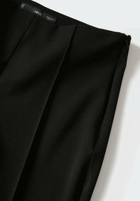 Black pleated skirt made of smooth fabric, featuring a side zip closure and a clean finish. No visible patterns or accents.