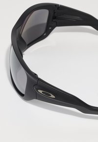Ochelari de soare sport negri cu un design elegant, lentile gri închis și accente argintii pe brațe. Construiți din materiale durabile, având o formă conturată.