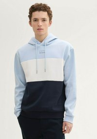 Jasnoniebieska i granatowa bluza z kapturem w technologii color-block, wykonana z miękkiego materiału, z regulowanym kapturem, przednią kieszenią oraz haftowanym logo na klatce piersiowej.