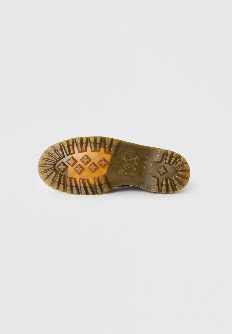 Semelle de chaussure en caoutchouc avec des motifs texturés, présentant un mélange de teintes brunes et orange. Des rainures profondes améliorent l'adhérence et la stabilité.