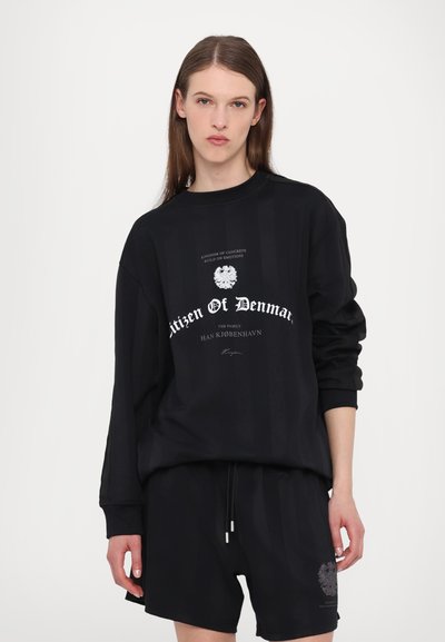 Black sweatshirt with long sleeves featuring a central graphic and text design. Complemented by matching black shorts, also with graphics.