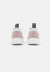 Baskets avec une tige en cuir blanc, des accents en daim rose et un onglet talon noir avec des lettres blanches. Semelle épaisse en caoutchouc blanc.