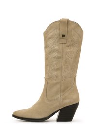 Bota vaquera de ante beige con punta puntiaguda, detalles bordados en la caña y tacón apilado diseñado para la estabilidad.