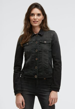Black denim jacket with long sleeves, button-up front, two chest pockets, and studded detailing on shoulders. Features copper buttons.