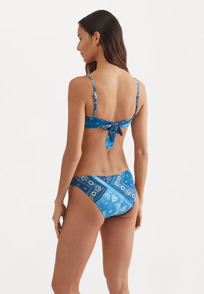 Blue bikini made of fabric with a bandana print, featuring adjustable straps and a tied back design; bottom has a similar pattern.
