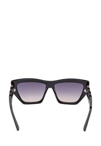 Occhiali da sole neri con un design angolare moderno, dotati di lenti a gradiente che passano dal scuro al chiaro. Montatura in acetato liscia con accenti subtili.