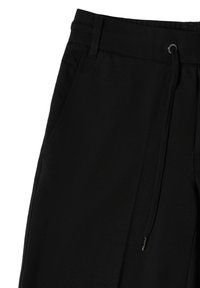 Zwarte broek met een elastische tailleband, zijzakken en een gladde stoffen textuur. Kenmerkt subtiele stiksels en geen zichtbare patronen.