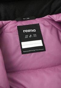 Wnętrze fioletowej kurtki puchowej z czarną metką z logo marki "reima", rozmiar 104 oraz ikonami opieki dotyczącymi wodoodporności i ochrony termalnej.