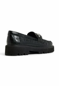 Black loafers with a crocodile texture, silver hardware detail, and chunky black rubber sole. Features a rounded toe and low profile.