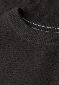 Dunkler Strickpullover mit einem gerippten Ausschnitt, weichem Material und zwei weißen Akzentlinien entlang des Kragens. Einheitliche Farbe im gesamten Pullover.