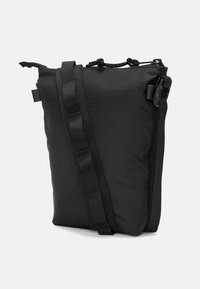 Borsa a tracolla nera in tessuto texture, con forma rettangolare, tracolla regolabile e imbottita, e chiusura a toggle nella parte superiore.