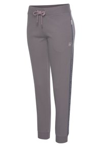 Graue Jogginghose mit einem Kordelzugbund, seitlichen Reißverschlusstaschen und Logodetails entlang der Seite. Hergestellt aus weichem, atmungsaktivem Material.