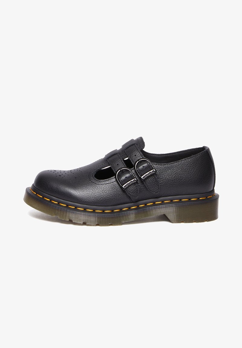 Chaussure Mary Jane en cuir noir avec double bride à boucle, bout perforé et semelle épaisse translucide avec couture jaune.
