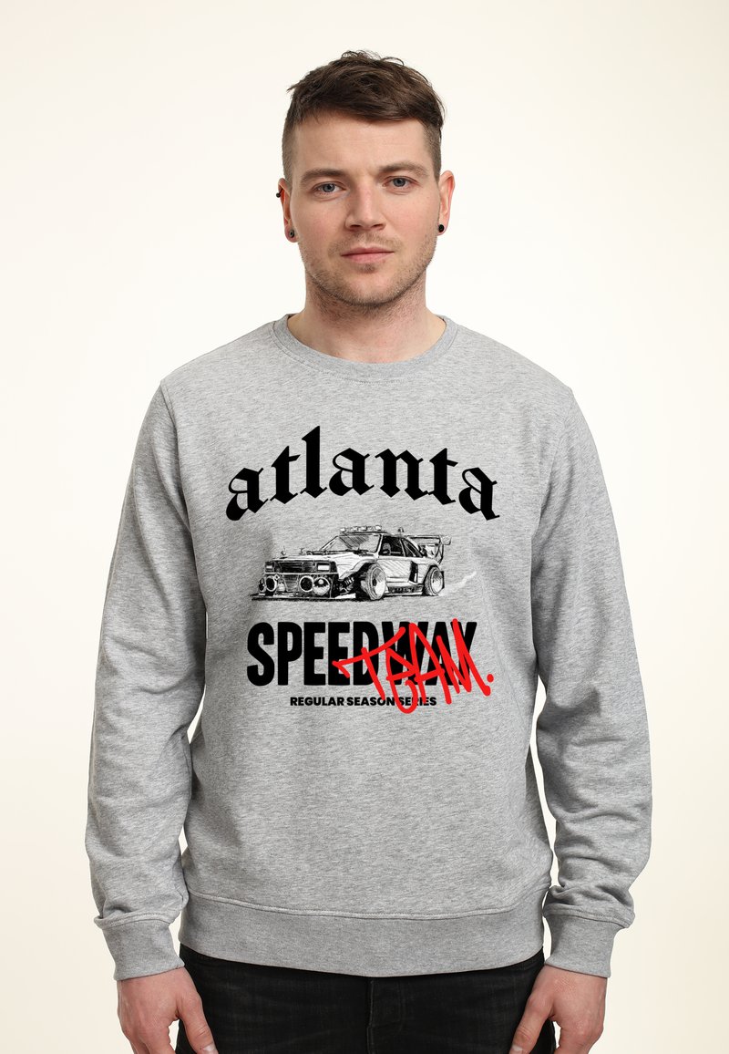 Šedá mikina se grafickým potiskem auta a textem v tučných černých a červených písmenech, včetně "Atlanta" a "Speedway".