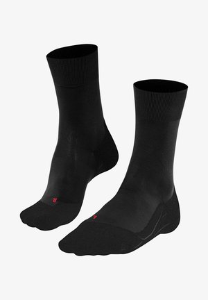 Schwarze Socken mit geripptem oberen Teil, glattem Körper und verstärkten Zehen. Mit kleinem rotem Logo an der Seite, entworfen für Komfort und Langlebigkeit.