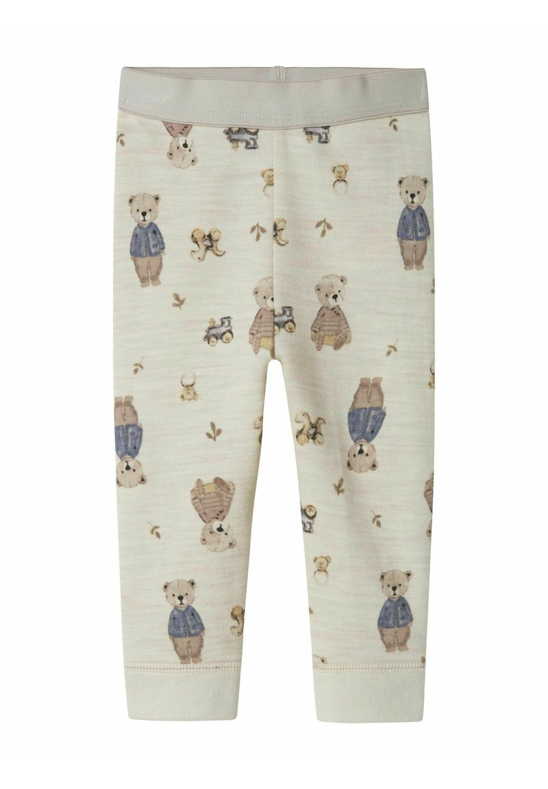 Krämliknande babyleggings med tryck av nallebjörnar och leksakståg, med björnar i blå jackor och bruna byxor.