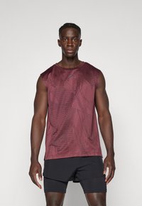 Burgunderfarbenes ärmelloses Sporttop mit einem strukturierten geometrischen Muster; kombiniert mit schwarzen Sportshorts. Der Stoff wirkt leicht und atmungsaktiv.