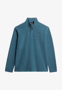 Sudadera de polar color teal con cuello alto, cremallera de cuarto y un pequeño logo en el lado izquierdo. Cuenta con mangas largas y un dobladillo recto.