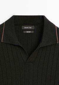 Černé bavlněné polokošile s ribbelovanou strukturou, s výstřihem do V a kontrastním béžovým lemem na límci. Štítek nese nápis "Massimo Dutti."