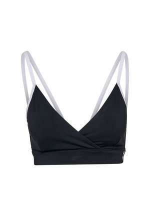 Brassière de sport noire avec un design croisé, dotée de bretelles réglables blanches. Fabriquée dans un tissu lisse, elle a un col en V profond et ne contient pas de rembourrage.