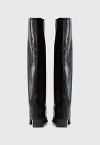 Black leather knee-high boots with a smooth texture, square heels, and a sleek design, featuring subtle stitching along the seams.