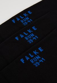 Calcetines negros con texto azul que dice "FALKE RUN 39-41," con una textura suave y tejida y un diseño clásico.