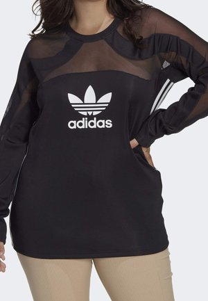 Czarny top z długim rękawem wykonany z gładkiej tkaniny z przezroczystymi panelami z siateczki. Posiada białe logo Adidas oraz paski na rękawach.