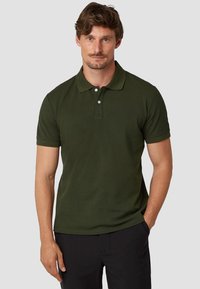 Donkergroene polo shirt van katoen met een kraag, korte mouwen en een placket met twee knopen; gladde textuur, getailleerd ontwerp.