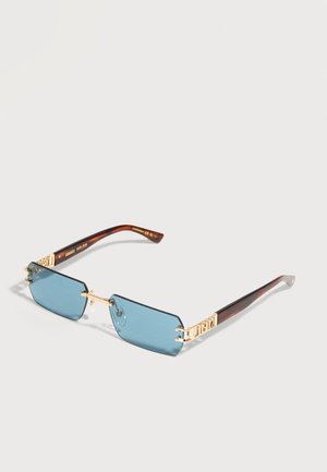 Occhiali da sole rettangolari blu senza montatura con ponte dorato e aste marrone tartarugato, poggiati distesi su una superficie chiara.