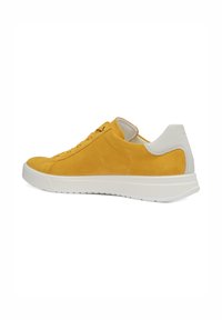 Yellow suede sneaker with white heel accent and white rubber sole, shown from side on white background.