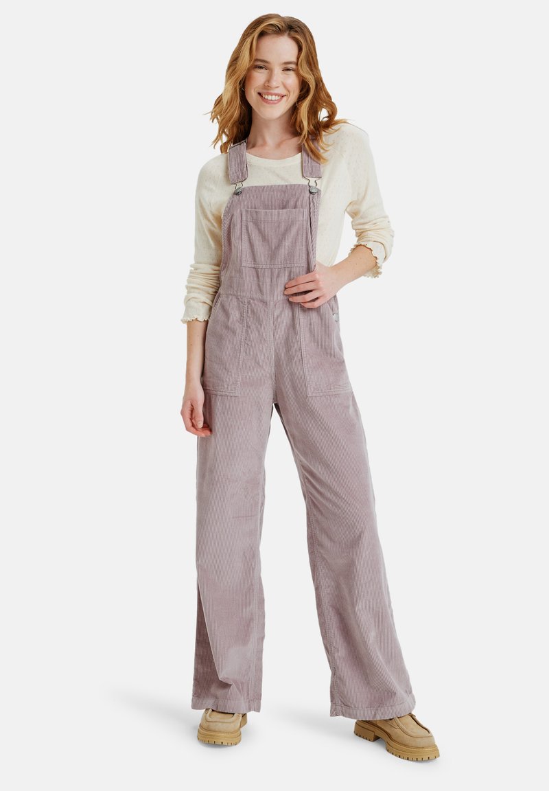 Paarse corduroy salopette met wijde pijpen, voorzien van verstelbare schouderbanden, een voorzak en een gestructureerde afwerking, gecombineerd met een crèmekleurige top.