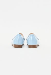 Light blue patent leather shoes with a rounded toe and low brown heel, featuring a smooth texture and subtle stitching details.