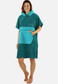 Türkisfarbener Kapuzenponcho mit einem kontrastierenden helleren türkisfarbenen Saum und Tasche; weiche, handtuchähnliche Textur; seitliche Schlitze für mehr Bewegungsfreiheit.