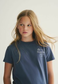 Námorně modré bavlněné tričko s jemnou strukturou, krátkými rukávy, kulatým výstřihem a bílým potiskem loga na hrudi.