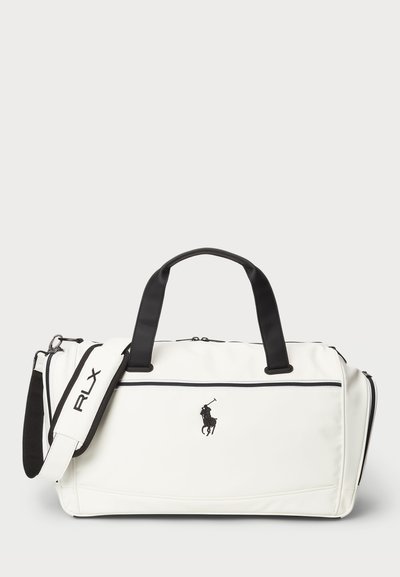 Vit duffelväska med svarta detaljer, med en framficka med dragkedja, dubbla handtag och justerbar rem. Broderad logga på framsidan.