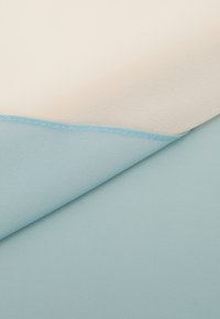 Two layers of fabric: a light cream top layer and a soft aqua blue bottom layer, displaying smooth textures with a fine stitching detail.