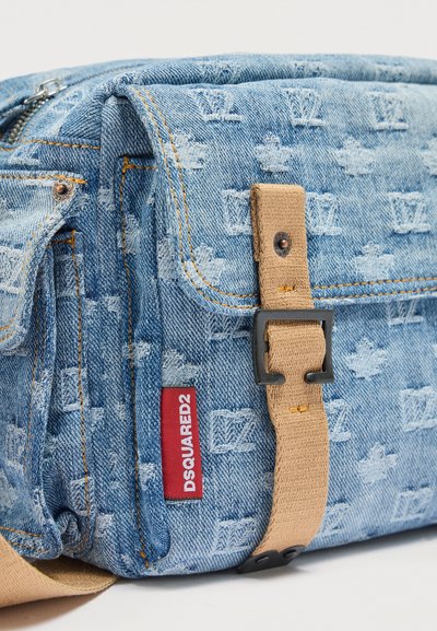 Τσάντα ώμου από denim με ανάγλυφα μοτίβα φύλλου σφενδάμου και λογότυπο 'DSquared2', μπεζ ιμάντα με αγκράφα και κόκκινη ετικέτα της μάρκας στην πλαϊνή τσέπη.