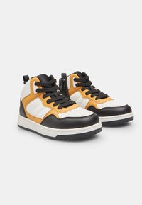 Zwarte, witte en gele hoge sneakers van leer en synthetische materialen. Geperforeerde neus, zwarte veters en een rubberen zool.