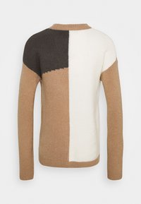 Pull en tricot avec un motif en blocs beige, marron et crème, col rond et manches longues. Texture douce.