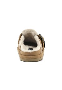Pantofole in camoscio marrone con una soffice fodera bianca, design aperto sul retro e una fibbia nera decorativa. Suola testurizzata per una maggiore aderenza.