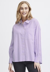 Lavender and white striped button-up shirt with a collar, feature a chest pocket, and long sleeves with buttoned cuffs. Soft fabric texture.