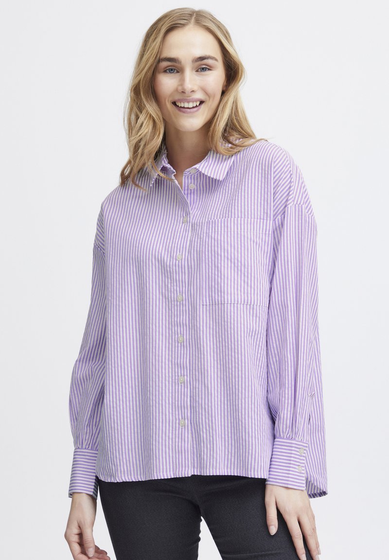 Lavender and white striped button-up shirt with a collar, feature a chest pocket, and long sleeves with buttoned cuffs. Soft fabric texture.