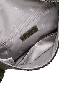 Green leather bag featuring a gray lining with repeated logo pattern, zippered pocket, and a tag with embossed text.