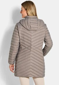 Lichtgewicht pufferjack in een zachte taupekleur, met een capuchon en een chevron-quiltpatroon. Lange mouwen met geribbelde boorden.